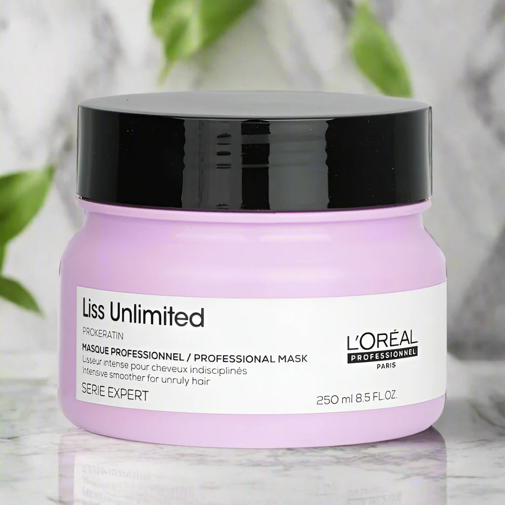 L'Oreal Liss Unlimited hair mask jar on a marble surface with green leaves in the background