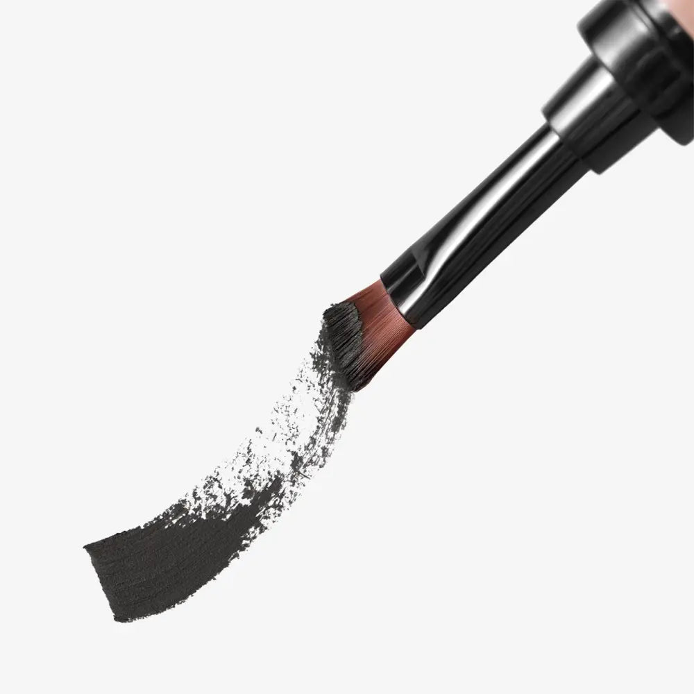 Makeup brush with black powder on a white background