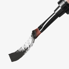 Makeup brush with black powder on a white background