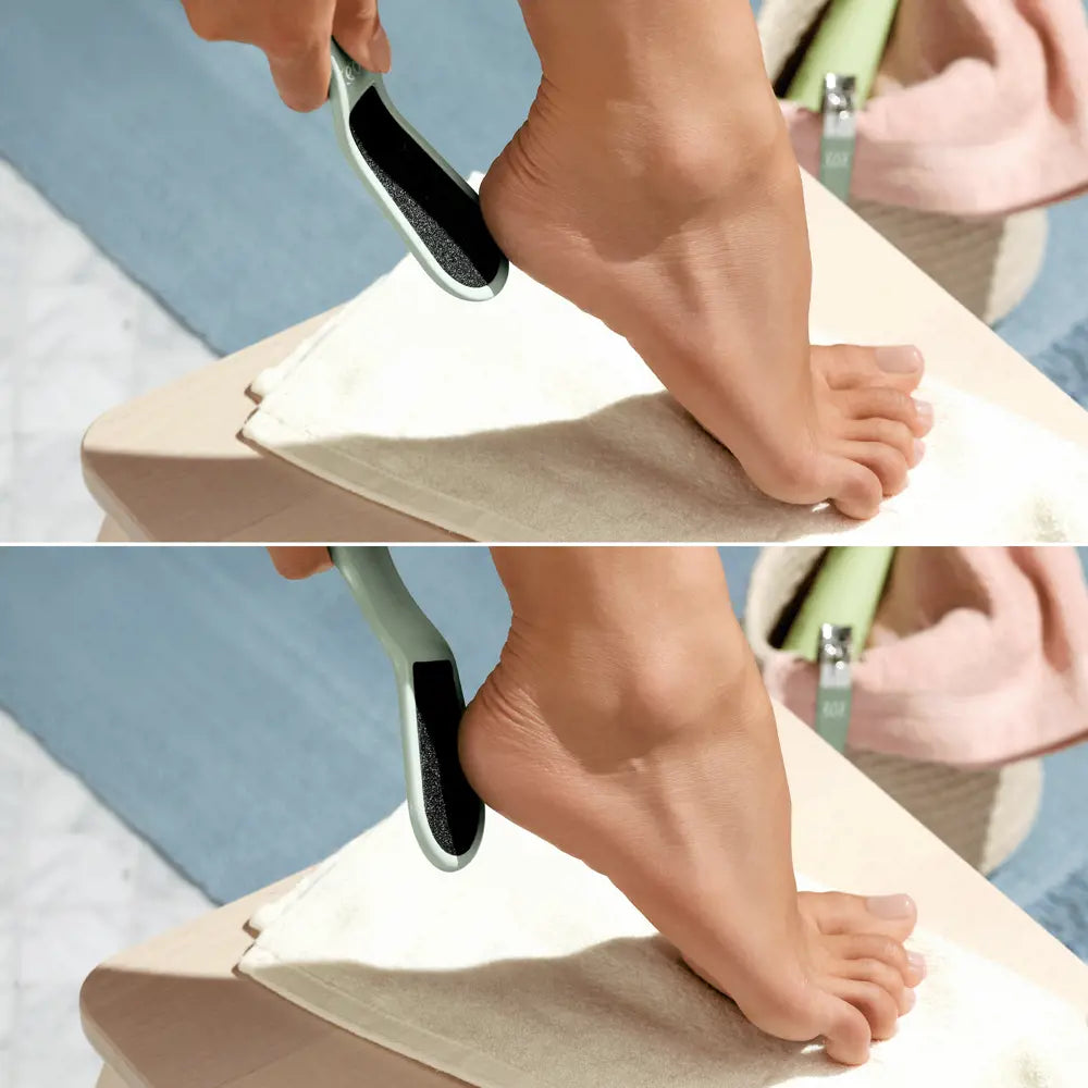 Person using a foot scrubber on their feet with a towel underneath.