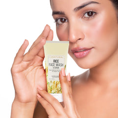 Woman holding a Conatural Rice Face Wash & Scrub with a neutral background