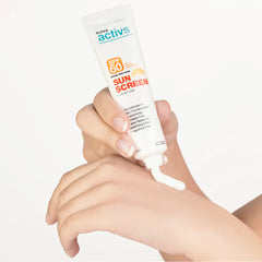 Hand applying sunscreen cream from a tube labeled 'Super Activs' on a white background