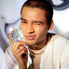 Man holding a 'SCOPE' perfume bottle with a blurred background