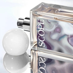 Perfume bottle labeled 'SCOPE' with artistic design on a reflective surface