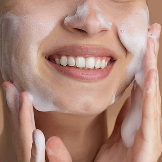 Person applying a foamy skincare product to their face