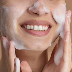 Person applying a foamy skincare product to their face