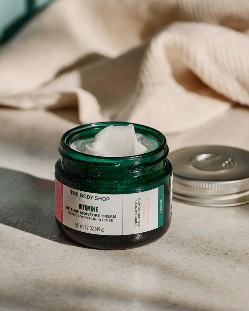 Jar of The Body Shop Vitamin E Intense Moisture Cream on a neutral background